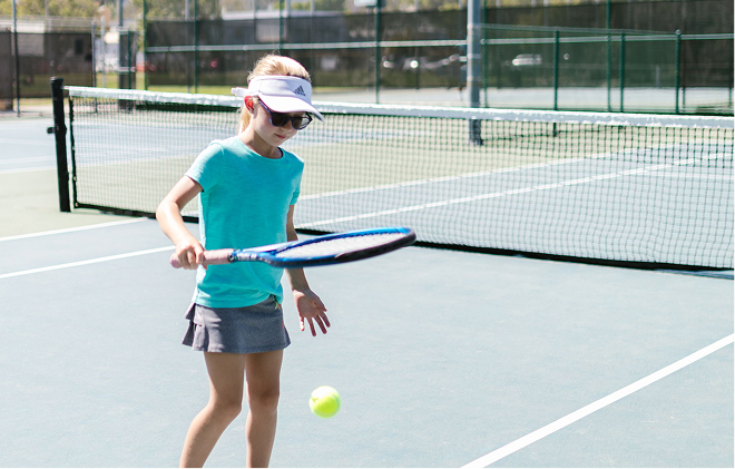 A player bouncing a ball on her racket